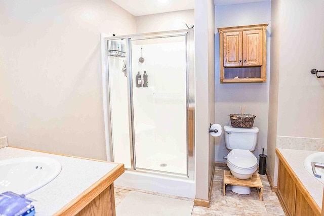 bathroom featuring toilet, a shower stall, and vanity