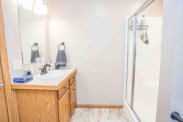 bathroom featuring a stall shower, baseboards, and vanity