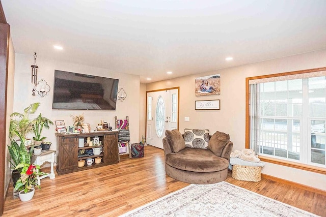 living area with recessed lighting, baseboards, and light wood finished floors