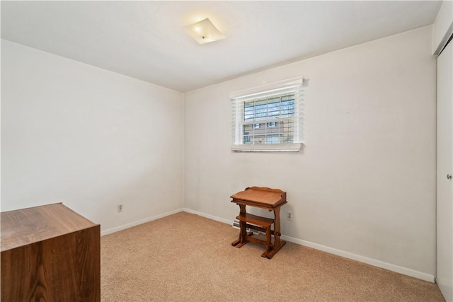 spare room with baseboards and light colored carpet