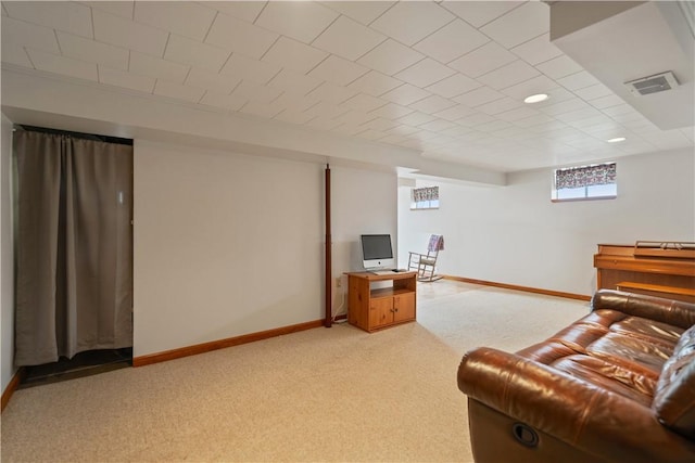 living area with visible vents, baseboards, and light colored carpet