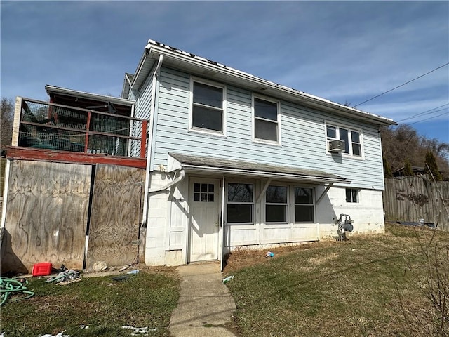 back of property with cooling unit, a yard, and fence