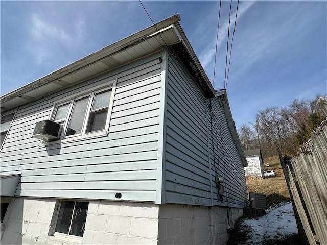 view of side of home featuring fence