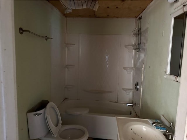 bathroom featuring washtub / shower combination, a sink, and toilet