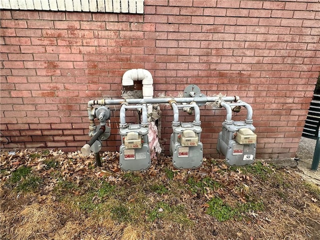 exterior details featuring gas meter and brick siding