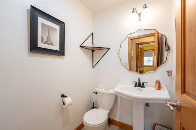 bathroom featuring toilet and baseboards