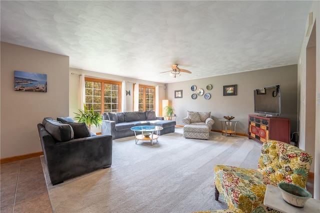 carpeted living room with ceiling fan, baseboards, and a textured ceiling