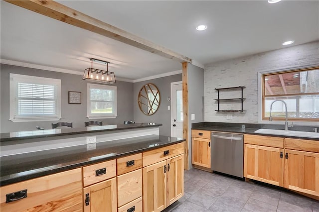 kitchen with dark countertops, dishwasher, a sink, and light brown cabinetry