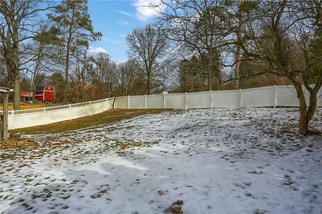 yard covered in snow with a fenced backyard