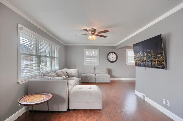 living room featuring ceiling fan, wood finished floors, visible vents, baseboards, and crown molding