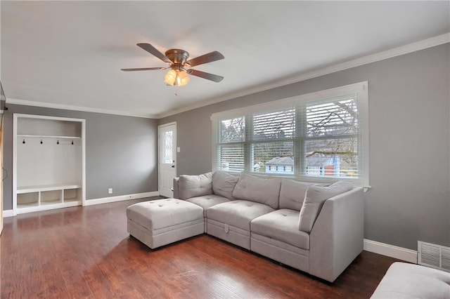 living room with dark wood-type flooring, visible vents, and crown molding