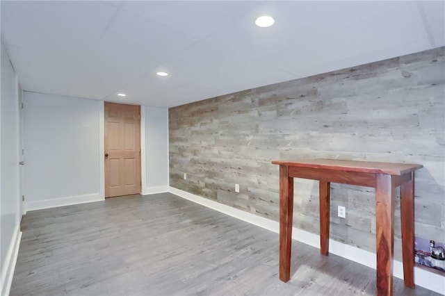 finished below grade area with baseboards, wood finished floors, and recessed lighting