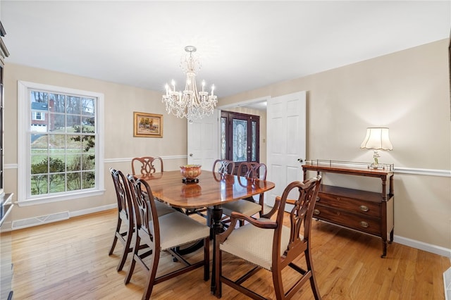 dining room with baseboards, a chandelier, visible vents, and light wood-style floors