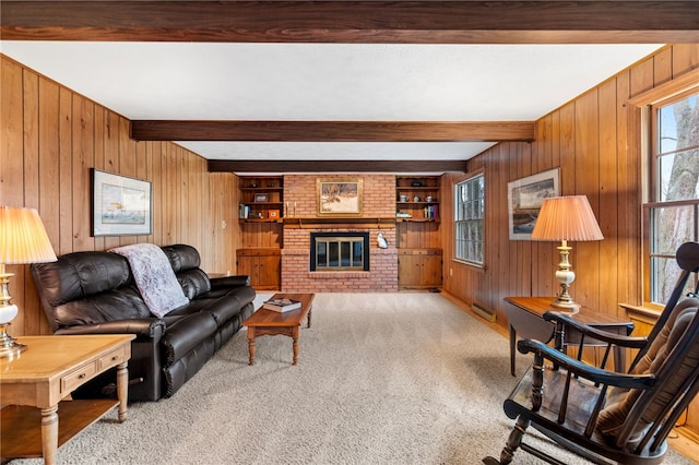 living room featuring wooden walls, a fireplace, beam ceiling, and light colored carpet