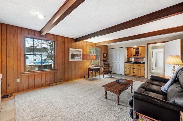 living room featuring beam ceiling, a baseboard radiator, wooden walls, a textured ceiling, and baseboards