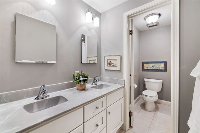 bathroom with double vanity, tile patterned flooring, toilet, and a sink