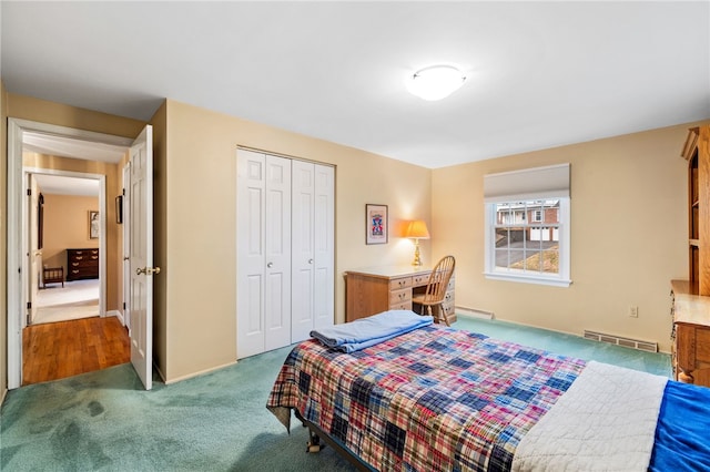 carpeted bedroom featuring visible vents and a closet