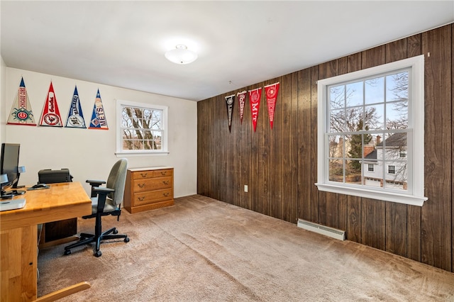 home office featuring a baseboard radiator, wood walls, and carpet