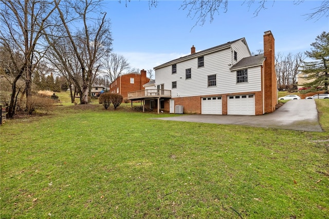 back of property featuring brick siding, a lawn, driveway, and an attached garage