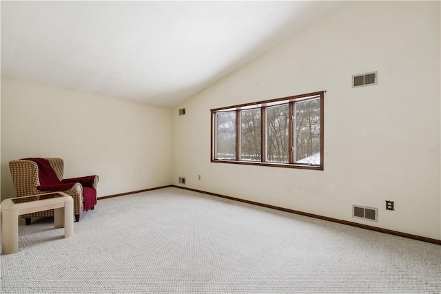 unfurnished room featuring light colored carpet, visible vents, and vaulted ceiling