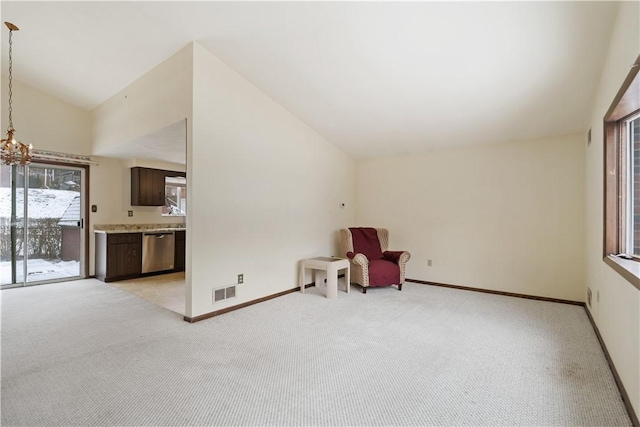 unfurnished room with lofted ceiling, baseboards, visible vents, and light colored carpet