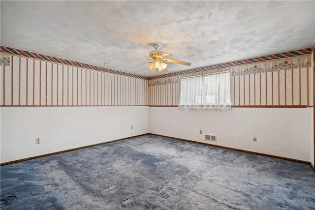 carpeted empty room with wallpapered walls, ceiling fan, visible vents, and baseboards