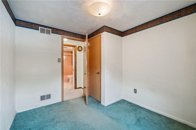 carpeted spare room featuring visible vents and baseboards