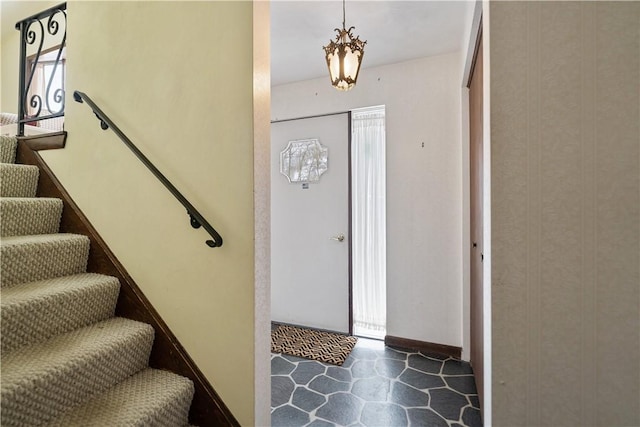 foyer with baseboards and stairs