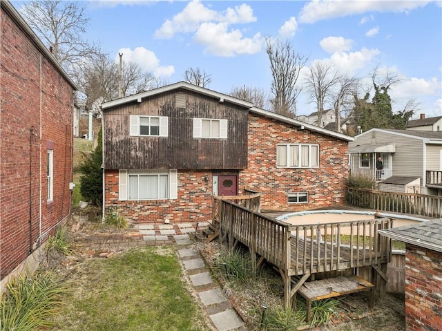 back of house with a deck and brick siding