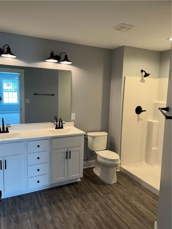115 White Fox Ct Unit 33, North Sewickley Twp, PA 16117 - bathroom featuring wood finished floors, double vanity, toilet, a shower, and baseboards