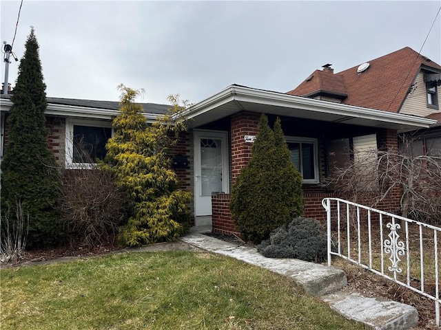 view of front of property featuring brick siding and a front yard