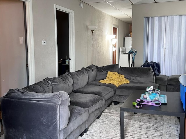 living area with a paneled ceiling