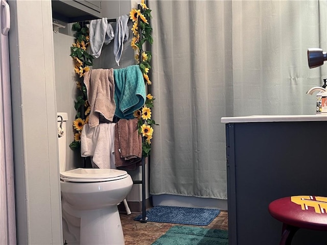 bathroom featuring toilet and curtained shower