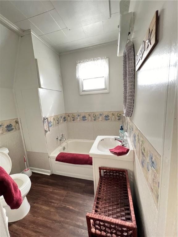 full bath featuring toilet, wood finished floors, vanity, tile walls, and a bath