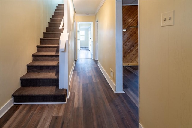 hallway featuring dark wood-style floors, stairs, baseboards, and crown molding