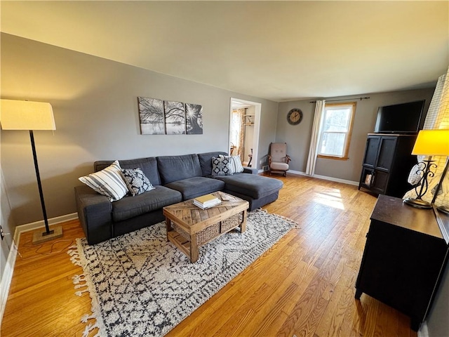 living area featuring light wood-style floors and baseboards