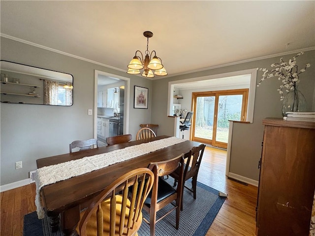 dining space featuring a chandelier, visible vents, baseboards, ornamental molding, and light wood-type flooring