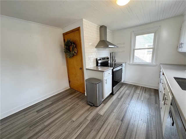 kitchen featuring white cabinets, wood finished floors, stainless steel appliances, wall chimney range hood, and backsplash