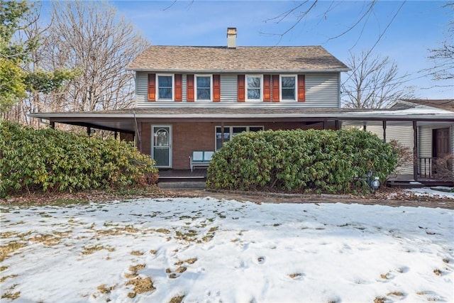 view of front of house featuring a chimney and a porch