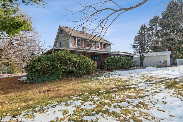 view of snow covered exterior with a chimney