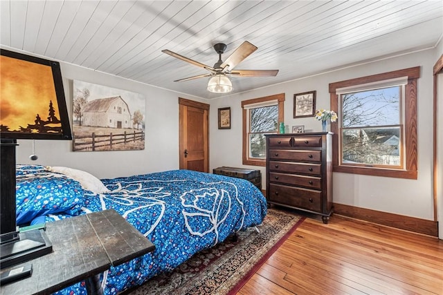 bedroom featuring a ceiling fan, wood ceiling, baseboards, and hardwood / wood-style floors