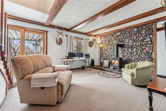 carpeted living room featuring beam ceiling, a textured ceiling, and a wood stove