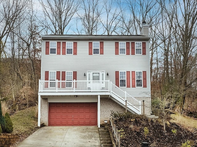 view of front of home with an attached garage, brick siding, stairs, concrete driveway, and a chimney