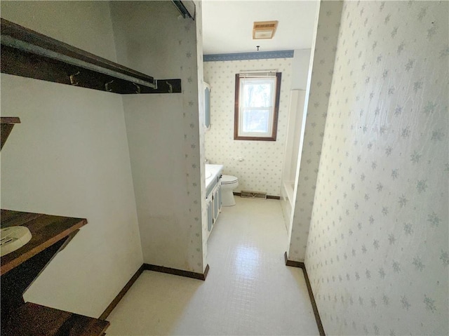 full bathroom featuring baseboards, a shower, toilet, and wallpapered walls