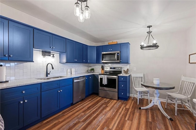 kitchen with dark wood-style flooring, decorative light fixtures, decorative backsplash, appliances with stainless steel finishes, and a sink