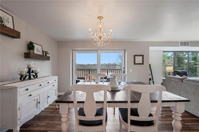 dining space featuring a healthy amount of sunlight, visible vents, dark wood finished floors, and a notable chandelier