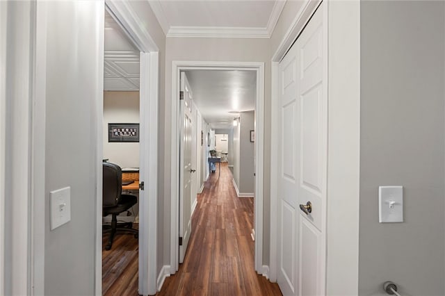 hall featuring dark wood-style floors, ornamental molding, and baseboards