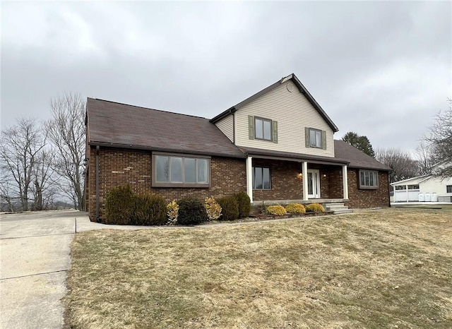 traditional-style home with a front lawn and brick siding