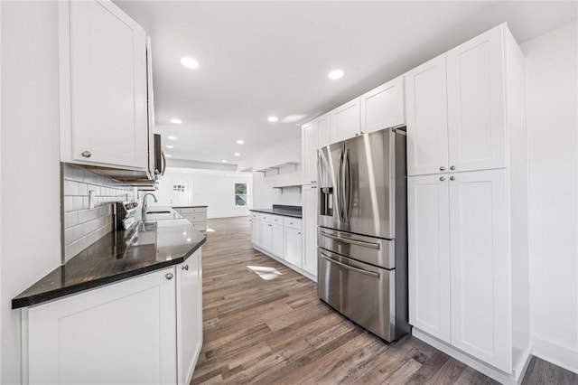 kitchen with a sink, appliances with stainless steel finishes, dark wood finished floors, and white cabinets