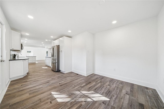 kitchen with stainless steel appliances, dark countertops, recessed lighting, white cabinetry, and light wood-type flooring